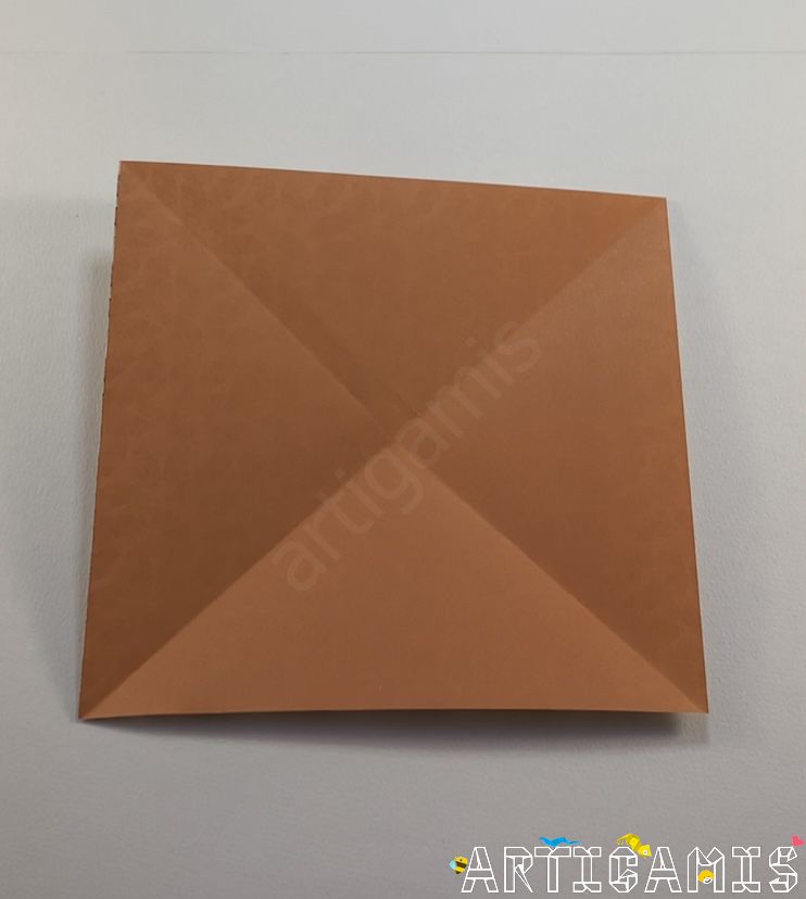 Step 2: Fold the sheet in half at the corners and unfold.